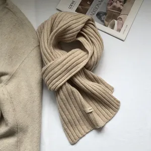 Detailed texture of beige 100% wool knit scarf with premium vertical rib-knit pattern