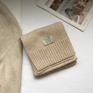 Detailed view of beige 100% Australian wool scarf featuring a fine knit texture and ribbed edge