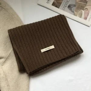 Detail of soft 100% wool scarf in dark brown featuring a classic vertical ribbed knit texture