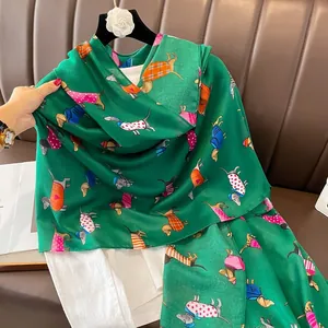 Détail d'une écharpe vert foncé avec des teckels colorés aux tenues à motifs