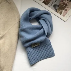 Detailed texture of 100% pure wool scarf in light blue with fine rib knitted edges