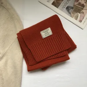 Detail shot of 100% Australian wool scarf featuring ribbed knit hem and woven label