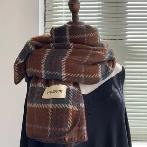 Gros plan d'une écharpe à carreaux en cachemire avec étiquette sur un tricot noir