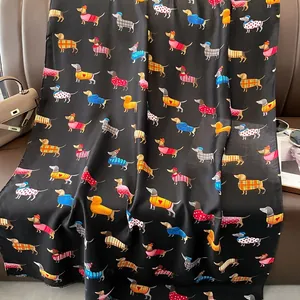 Détail de motif de teckels en pulls sur une écharpe noire en coton et lin de qualité
