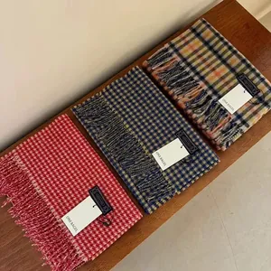Three premium wool scarves with tassel trim and assorted plaid patterns in cozy warm tones