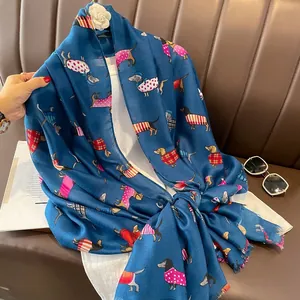 Détail d'une écharpe en coton et lin bleue avec des motifs de teckels colorés