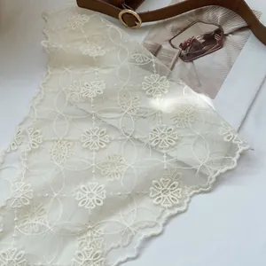 Close-up of cream lace bandana with sunflower embroidery and scalloped edges