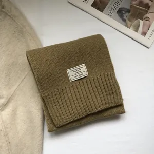 Macro detail of 100% Australian wool scarf featuring woven label and ribbed edges