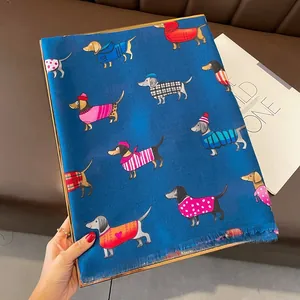 Détail d'une écharpe bleu foncé avec motifs de teckels mignons et bords à franges