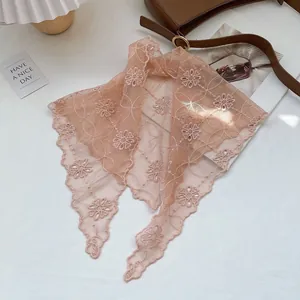 Detail of apricot pink lace headscarf featuring delicate floral embroidery and wavy edges