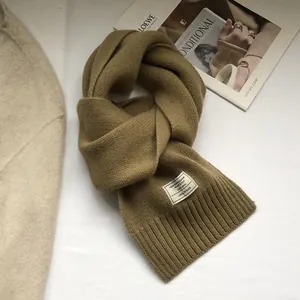Close-up of 100% Australian wool scarf with knit texture and fabric brand label