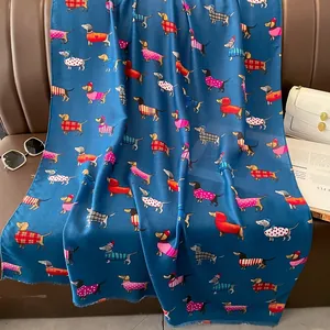 Détail de l'écharpe bleu foncé présentant des motifs de teckel sur un tissu lisse