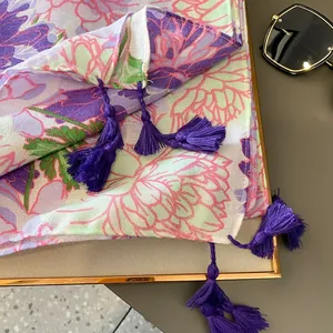 Detail eines lebhaften Blumentuchs mit lila Fransen und Vintage-Blumenmuster
