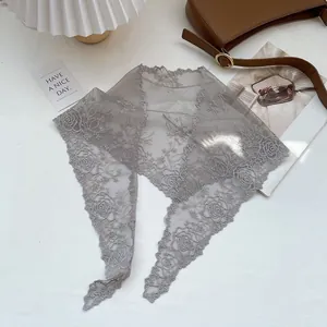 Detailed close-up of grey lace triangle scarf with intricate rose floral patterns