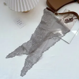 Detail view of vintage grey lace triangle scarf with rose embroidery on white tabletop
