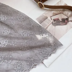 Close-up of grey lace headscarf with delicate floral embroidery and scalloped edges