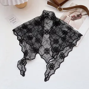 Detailed view of elegant black floral lace scarf with delicate scalloped edges on white background