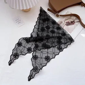 Macro shot of elegant black lace headscarf with intricate floral hollow patterns