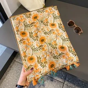 Lightweight scarf with orange floral print and tassel fringe for a summer resort look