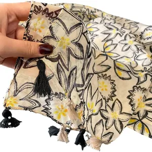 Écharpe en coton et lin à fleurs avec détails jaunes et glands bicolores sur les bords
