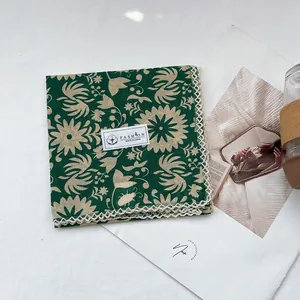 Detail of floral cotton scarf showing 100% cotton label and white lace edge