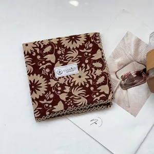 Detail showing 100% cotton floral scarf with delicate lace trim and soft fabric texture