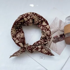 Detailed close-up of floral cotton linen scarf with elegant beige lace trim edges