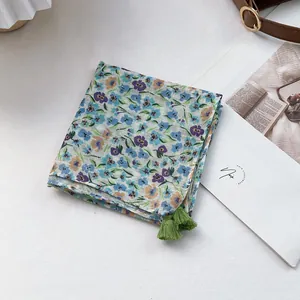 Floral cotton linen square scarf with tassels shown with fashion magazine and lifestyle props