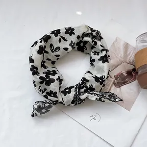 Detail shot of vintage floral cotton linen scarf with black patterns on off-white fabric