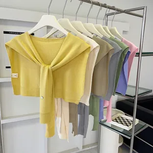Minimalist knit shawl for women in multiple colors hanging on a modern metal rack