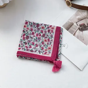 Detail of floral square scarf featuring magenta tassels and cotton-linen texture