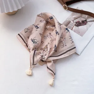 Light pink cotton scarf with horse print and tassels on white background