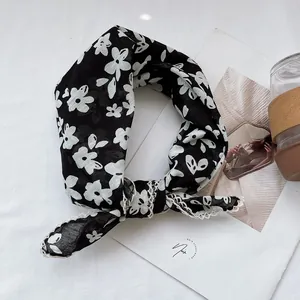 Close-up of black and white floral cotton scarf featuring delicate lace crochet edges