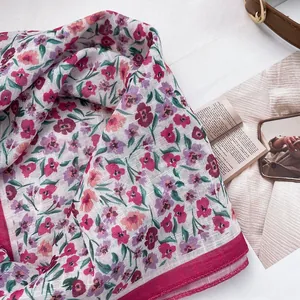 Close-up of floral cotton linen neckerchief showing delicate pink flowers and red border