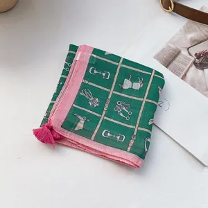 Detail of forest green square scarf with equestrian prints and pink tassels