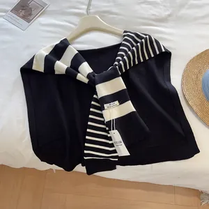 Detailaufnahme eines schwarz-weiß gestreiften Strickschals mit hochwertigem Markenetikett