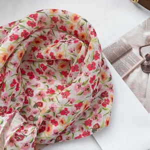 Detail of floral printed scarf showing lightweight mesh texture and delicate red flowers