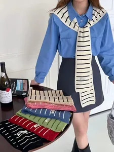 Détail de divers châles en tricot rayé avec étiquette tissée Bring You Happiness
