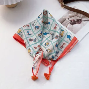 Detail shot of vintage equestrian pattern silk scarf with tassels and orange borders