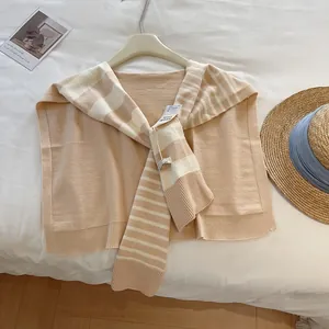 Detailansicht beige gestreifter Strickschal zum Binden mit Etikett im Scandi-Stil