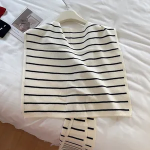 Détail de la maille douce et des rayures noires sur ce châle chic de couleur crème