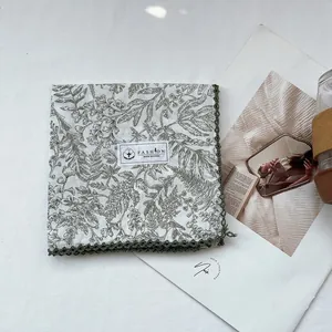 Detail of 100% cotton floral scarf with elegant olive green pattern and crochet lace edge
