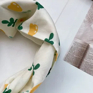 Nahaufnahme von Leinenmischung Haarband mit gelben Blumenmustern und Knotendesign