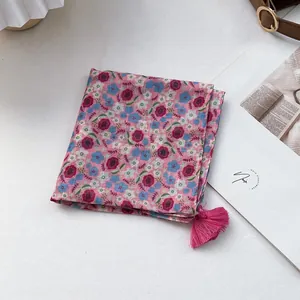 Detailed texture of pink floral cotton linen scarf with elegant fringe trim and patterns