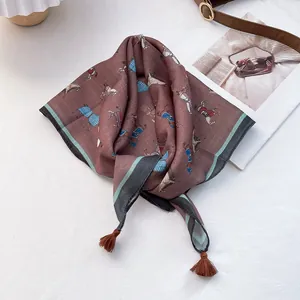 Detail of silk-feel square scarf with equestrian horse print and corner tassel accents