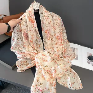 Detailed close-up of pink floral lightweight scarf with fringe edges and soft texture
