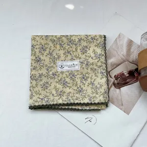 Detail of 100% cotton floral handkerchief with green lace trim and material label