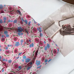 Detail shot of soft floral print scarf with fine woven texture and pastel blue patterns