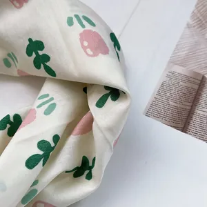 Detail eines Leinenschals mit zarten Tulpenmustern und weicher Stoffstruktur