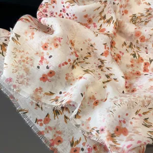 Close-up of vintage pink floral cotton scarf fabric with soft tassels and breathable texture